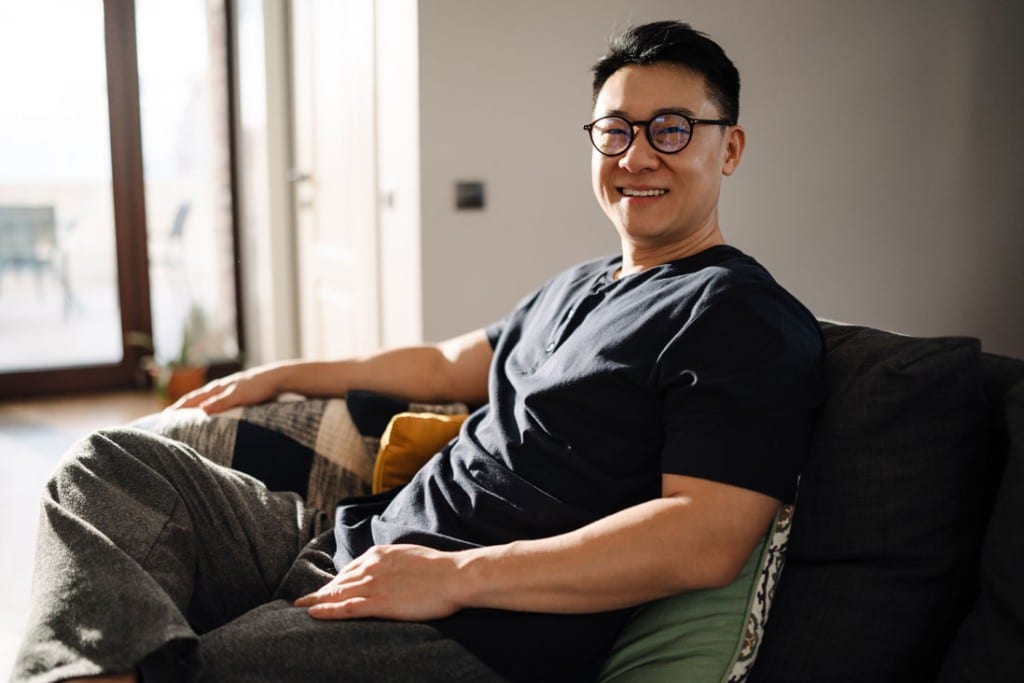 adult man lounging in chair and smiling